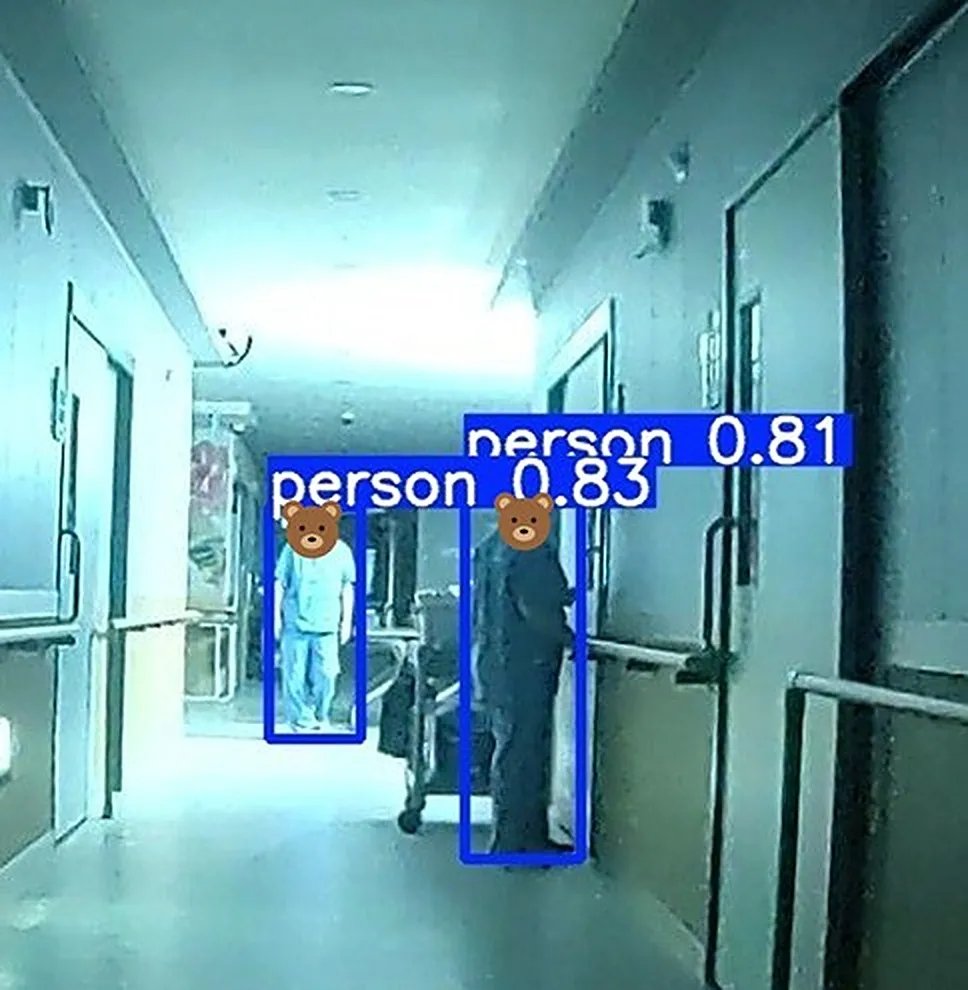 A photo of a facility corridor taken by the patrol robot, with the AI drawing blue boxes around two people. The boxes are labeled person 0.83 and person 0.81, and the faces are covered with a bear illustration.