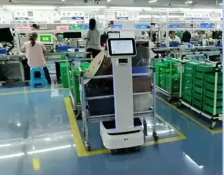 작업자와 초록색 선반이 있는 공장 통로의 로봇